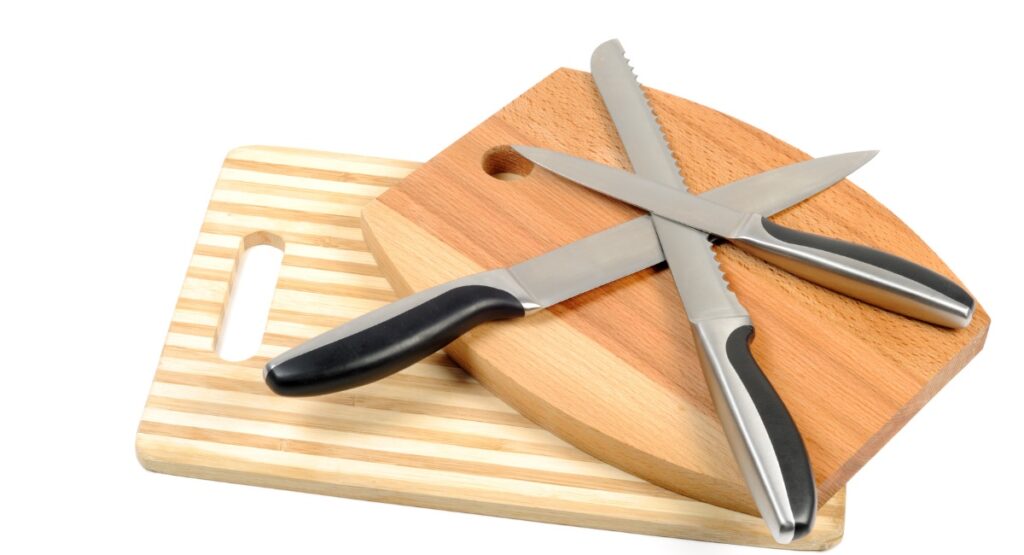 Photo of cutting boards and 3 different types of kitchen knives.