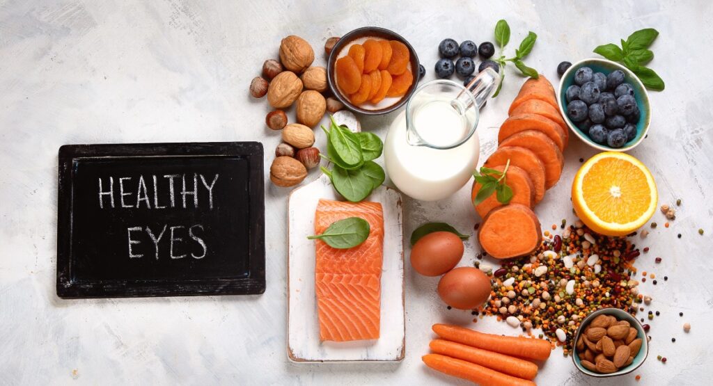 Image of foods that promote eye health, sweet potatoes, blueberries, nuts, eggs, carrots, salmon.