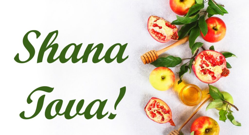 image of apples, honey, pomegrantaes, words saying Shana Tova